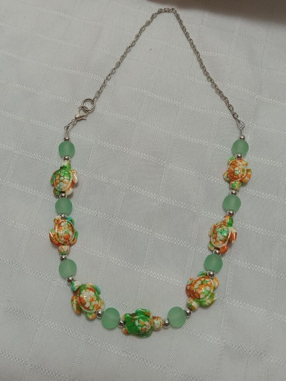 Pretty handmade necklace with  little turtles and glass bead
